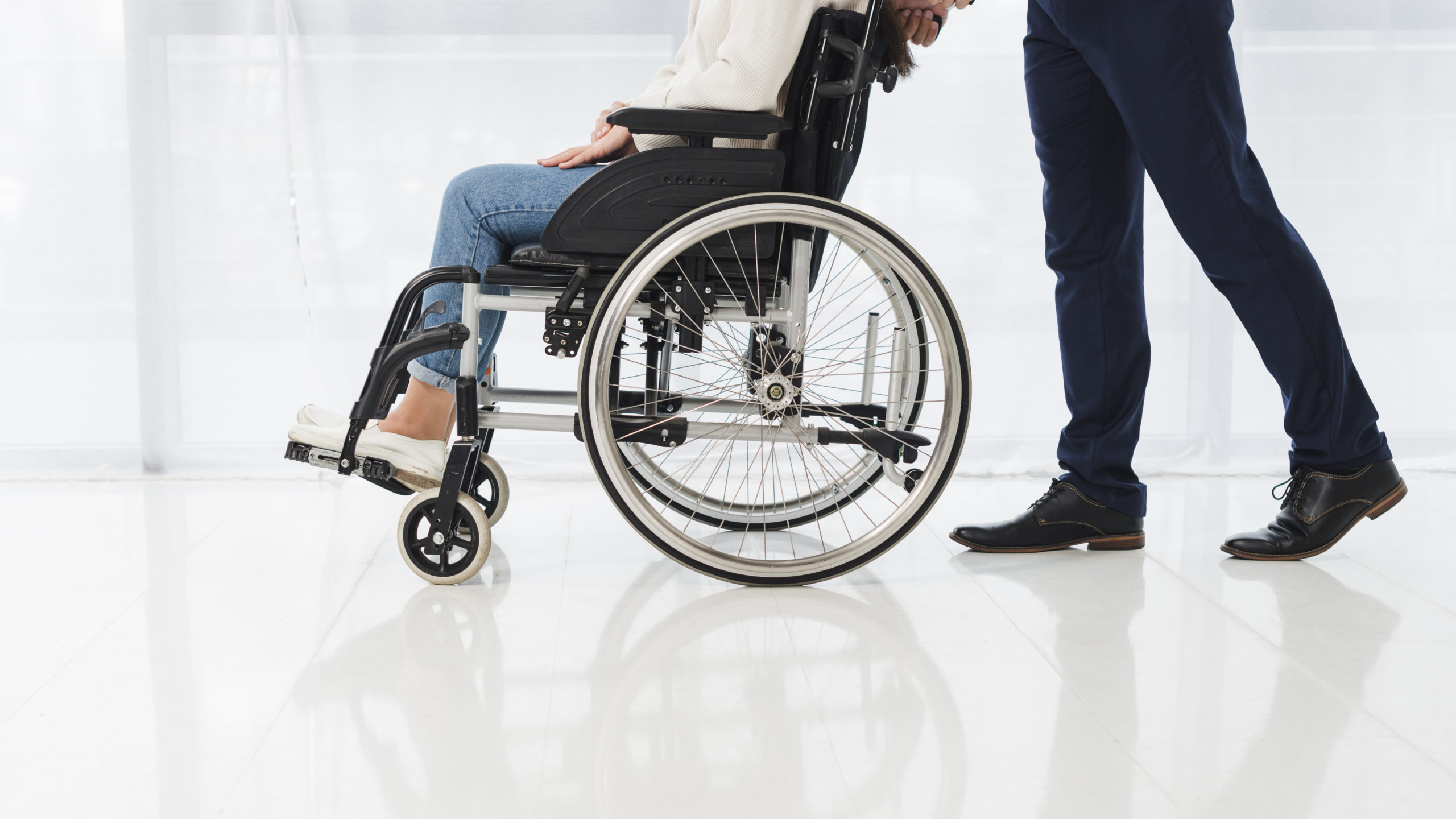 A Patient on a Wheel Chair pushed by a Person